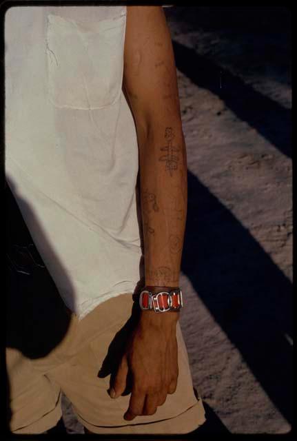 Boy standing, close view of tattoos on arms