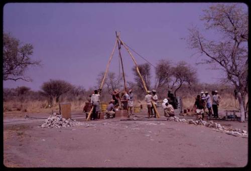 Group of people working on a bore hole for a water pump