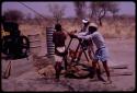 Group of people building a water pump; ǂToma and /Gao pulling on a rope