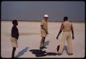 Claude McIntyre with two men deciding on direction of wind, placing old tires to burn for a smoke signal for a plane