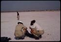 Leslie McIntyre and Claude McIntyre laying old tires to signal a plane, ǂToma standing in the background