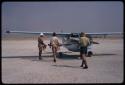 Claude McIntyre, Leslie McIntyre, and Leslie's friend approaching a plane