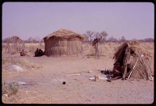 ǂToma's hut and skerms, with people sitting by them