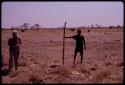 ǂToma standing beside the stick marking his land boundary, Lorna Marshall standing to the side