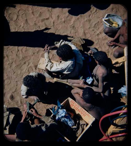 Expedition: Group of people sitting, holding gifts from expedition members, view from above