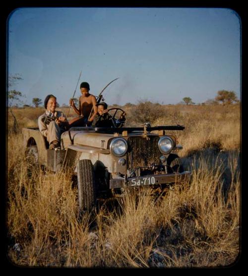 Expedition: Ngani driving Jeep, with John Marshall holding a camera and //Ao with hunting equipment