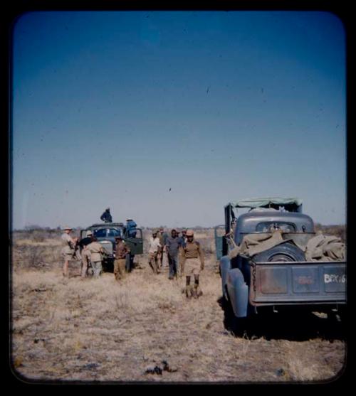 Expedition: Expedition members, including John Marshall and Ngani, gathered near three expedition trucks on their trip from "Kubi"