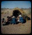 Expedition: Lorna Marshall interviewing a group of people by skerm, assisted by Ngani and Kernel Ledimo