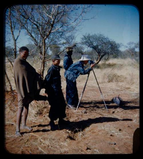 Expedition: Lorna Marshall photographing, with other people standing nearby