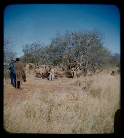 Expedition: Lorna Marshall photographing a group of people while John Marshall adjusting arrangements, with other expedition members present