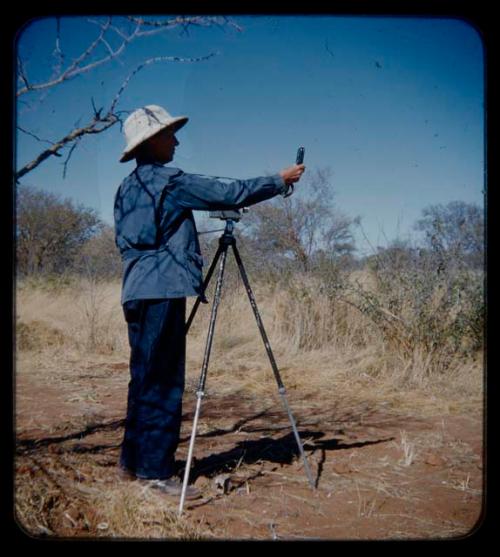 Expedition: Lorna Marshall reading light meter, with a camera positioned in front of her