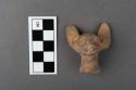 Pottery animal head showing traces of yellow paint.