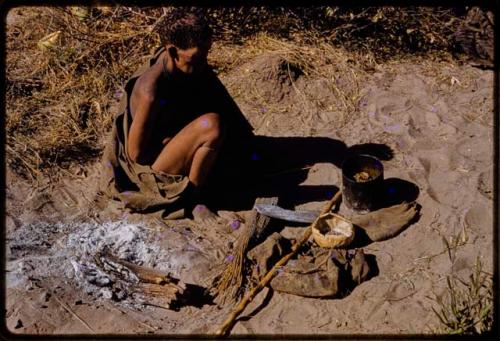 //Kuǂtera sitting, with her possessions on the ground in front of her