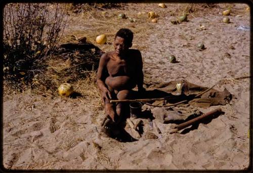 Oukwane sitting with his bow, tsama melons behind him