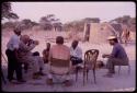 Kauguwa (Lukas), a prophet, receiving members of the expedition at his place, with Laurence Marshall taking a Polaroid photograph