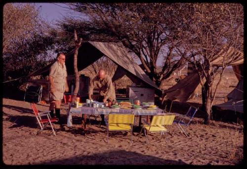 C.J. Mathias and O.P.M. Prozesky standing at the expedition camp breakfast table