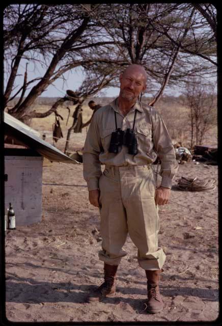 O.P.M. Prozesky standing with binoculars hanging around his neck, full-figure