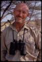 Portrait of O.P.M. Prozesky with binoculars hanging around his neck