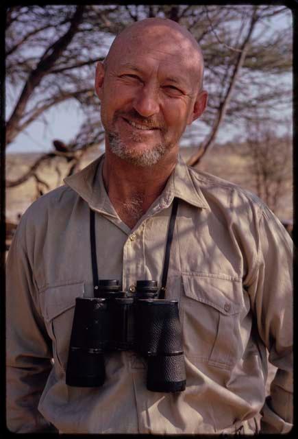 Portrait of O.P.M. Prozesky with binoculars hanging around his neck