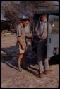 Kurt Ahrens and Nicholas England making a microphone shield, standing beside an expedition Land Rover