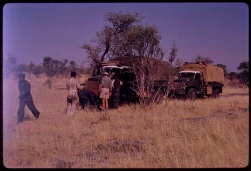 Expedition members looking at an expedition truck with a flat tire