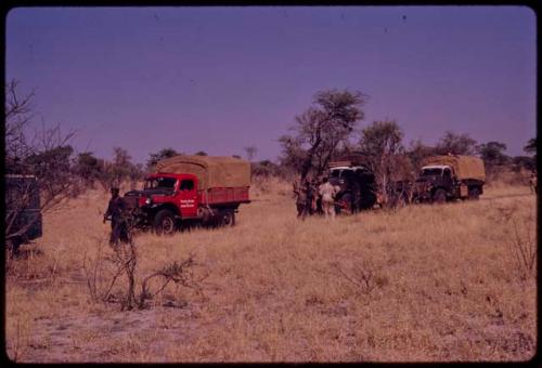 Expedition members gathered near an expedition truck with a flat tire