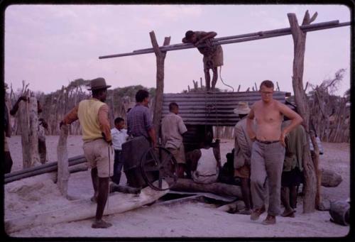 Group of men working on a broken pump at Rapita's well, with Nicholas England standing