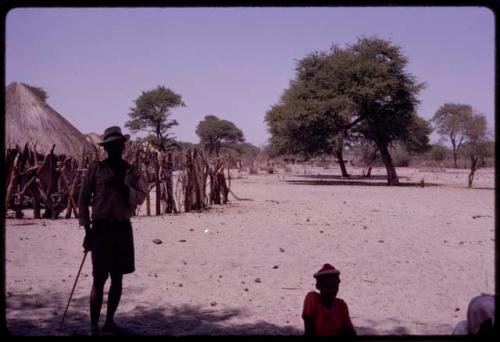 Man standing in an open space in front of Urobitsi's huts