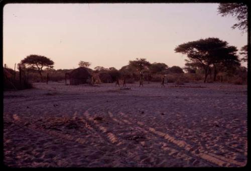 People walking, with huts across from Urobitsi's area