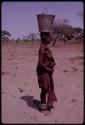 Woman holding a bucket of water on her head