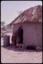 Person looking into "Old Daoku's" hut; "Old Daoku" is lying on his deathbed inside