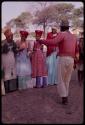 Kendyendye singing, with a group of women wearing "modern" Herero dress clapping