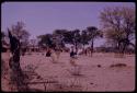 Group of women walking toward a church, with Lukas' village in the background