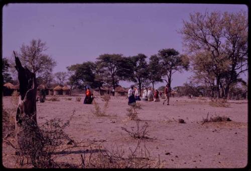 Group of women walking toward a church, with Lukas' village in the background