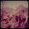 Groups, "Nuclear Family": Elderly woman who is blind, sitting with a group of people, including Bau (center)