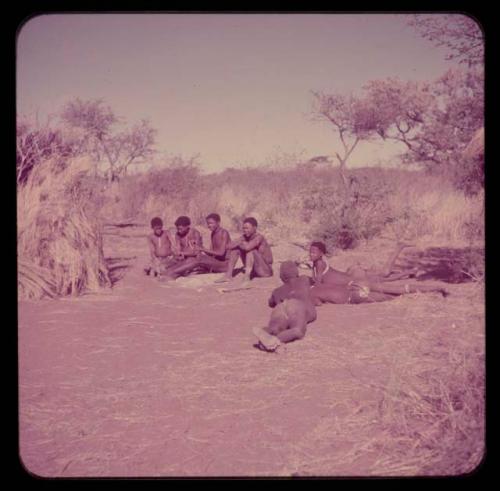 Music: "/Gao Music" playing a //guashi, sitting with a group of men including //Ao, !Naishi (his brother), Tsamgao and "Old Demi" lying down