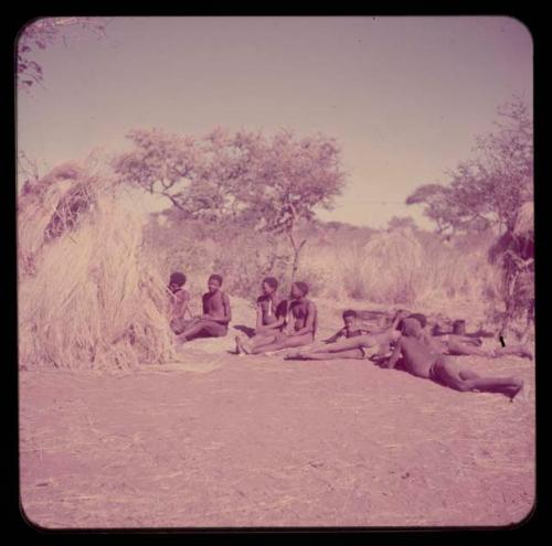 Music: "/Gao Music" playing a //guashi, sitting with a group of men including //Ao, !Naishi (his brother), Tsamgao and "Old Demi" lying down