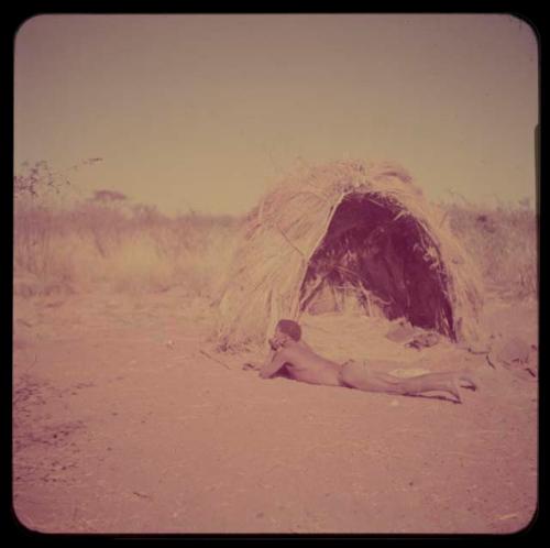 Portraits: Man lying down in front of a skerm with grass inside it