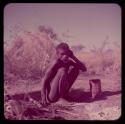 Portraits: "Old /Gishay" sitting, with a mortar on the ground in front of him, skerm in the background