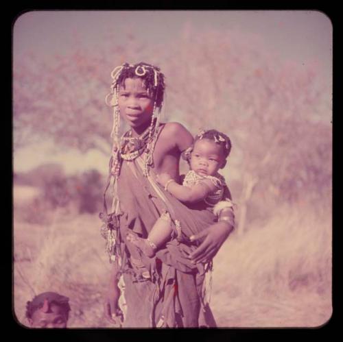 Children, Carrying: Girl of Band 10 carrying a baby in a sling, both wearing beaded ornaments