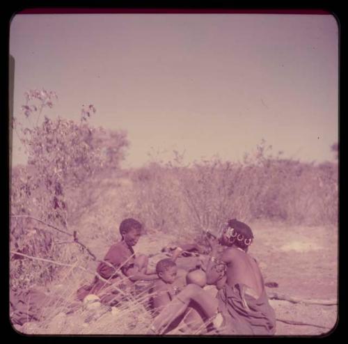 Smoking: !U smoking a pipe, sitting with her mother and two children