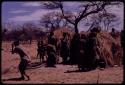 Women performing the Eland Dance, with some standing in front of a skerm, singing and clapping, and others dancing around the skerm