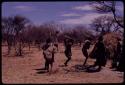 Group of people performing the Eland Dance, including three men wearing horns