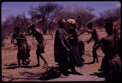 Group of people performing the Eland Dance, including two men wearing horns