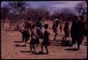 People performing the Eland Dance, with Twi imitating the sideways motion of an eland's hind legs and playing up to ǂKxoba