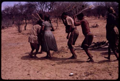 Group of people performing the Eland Dance, with Twi cutting in between ǂKxoba and the man in front of her