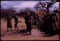 Group of people performing the Eland Dance, with !Ani followed by Tchobe