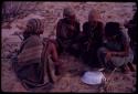 Women playing dandiri, including N/kxabe (daughter of /Oβa) with her foot on the stick, Tomku, Dadum, and ǂKxoba