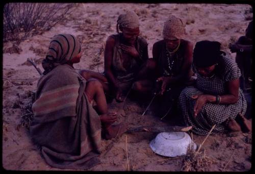 Women playing dandiri, including N/kxabe (daughter of /Oβa) with her foot on the stick, Tomku, Dadum, and ǂKxoba