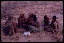 Women playing dandiri, including N/kxabe (daughter of /Oβa), Tomku, Dadum, and ǂKxoba, with a group of children sitting behind them